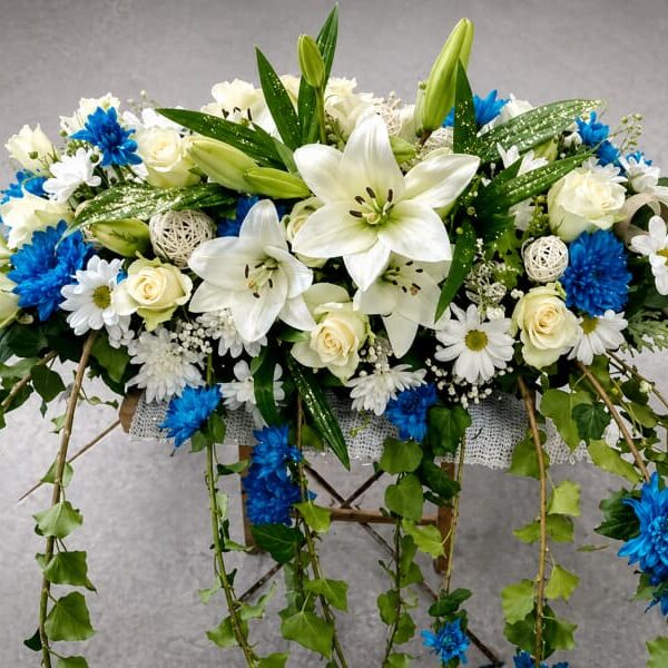 cvetni aranžman sa belim ljiljanima i plavim cvećem za dekoraciju