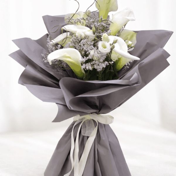 buket belih kala i ruža u sivom pakovanju