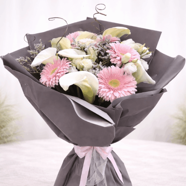 buket sa kalama ružama i roze gerberima u sivom pakovanju